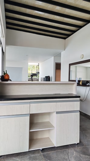 Una cocina moderna con acabados en madera clara, encimera negra y armarios empotrados.