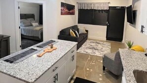 Een knus woongedeelte met een kitchenette, een eethoek en een slaapkamer.