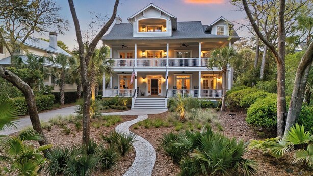 A two-story house with a front porch, a covered entryway, and a landscaped garden with pathways. - Stunning 7 BR Home on Eugenia, Private Pool, 100 yards to Beach! (Kiawah Island)