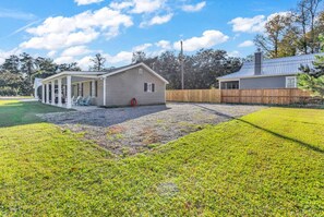 A single-story house with a covered porch and a fenced yard.