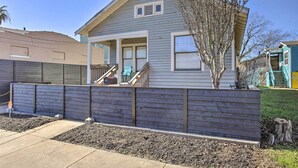 A single-story house with a front porch, a small deck, and a wooden fence. - Patio & Pergola! Modern Cottage Near Seawall (Galveston)
