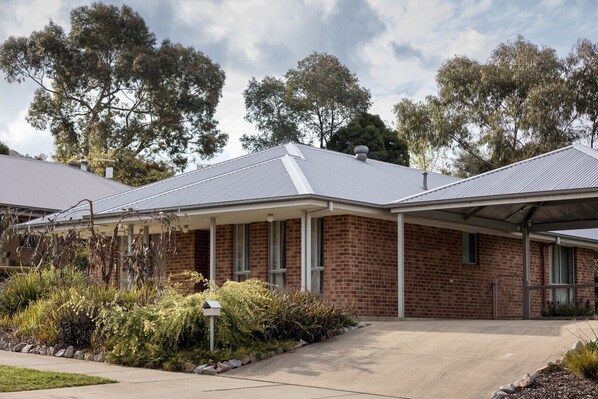 A brick building with a covered porch and a clear sky.