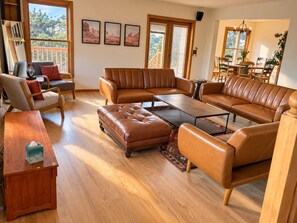 Una sala de estar con un sofá modular, una mesa de centro y una mesita de noche de madera.