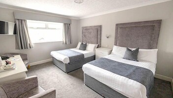 Een hotelkamer met twee bedden, een bureau en een stoel.