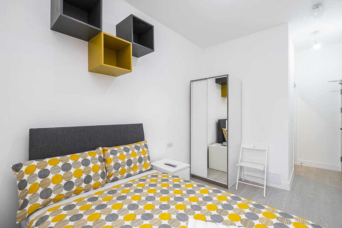 Un dormitorio moderno con cama, mesita de noche y armario.