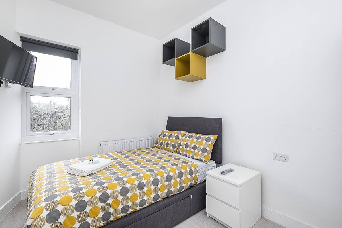 Un dormitorio moderno con cama, mesitas de noche y estantes empotrados.