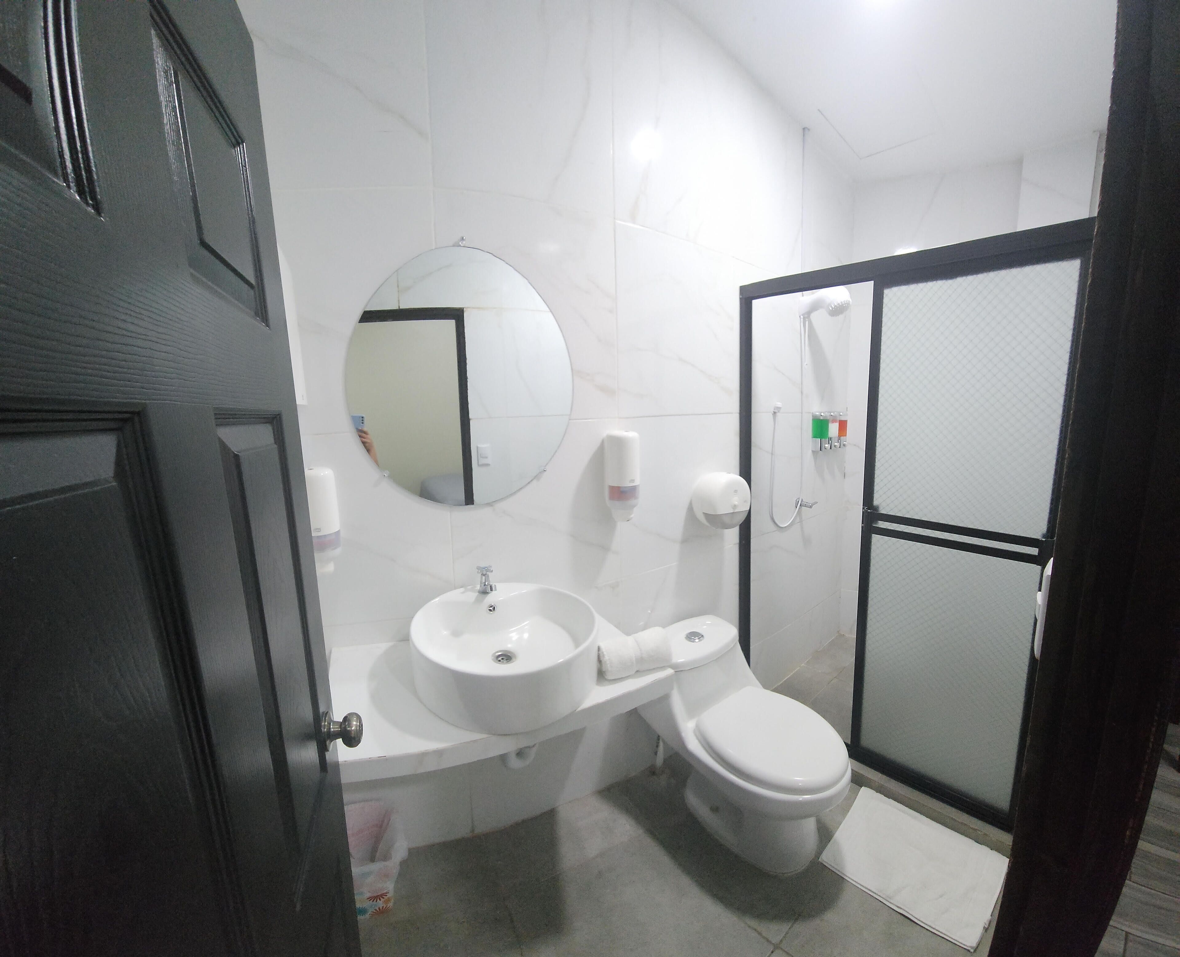 A bathroom with a sink, toilet, and a shower area.