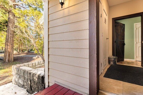 Enter a serene space with a welcoming door and a natural view.