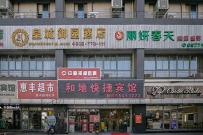 A multi-story building with various businesses, including a pharmacy, a bakery, and a restaurant. - Hedi Express Hotel, Hefei (Hefei)