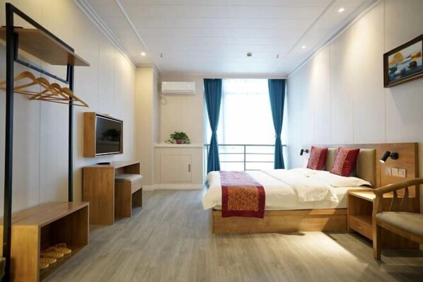 A bedroom with a bed, TV, wooden furniture, and a window with curtains. - Hedi Express Hotel, Hefei (Hefei)