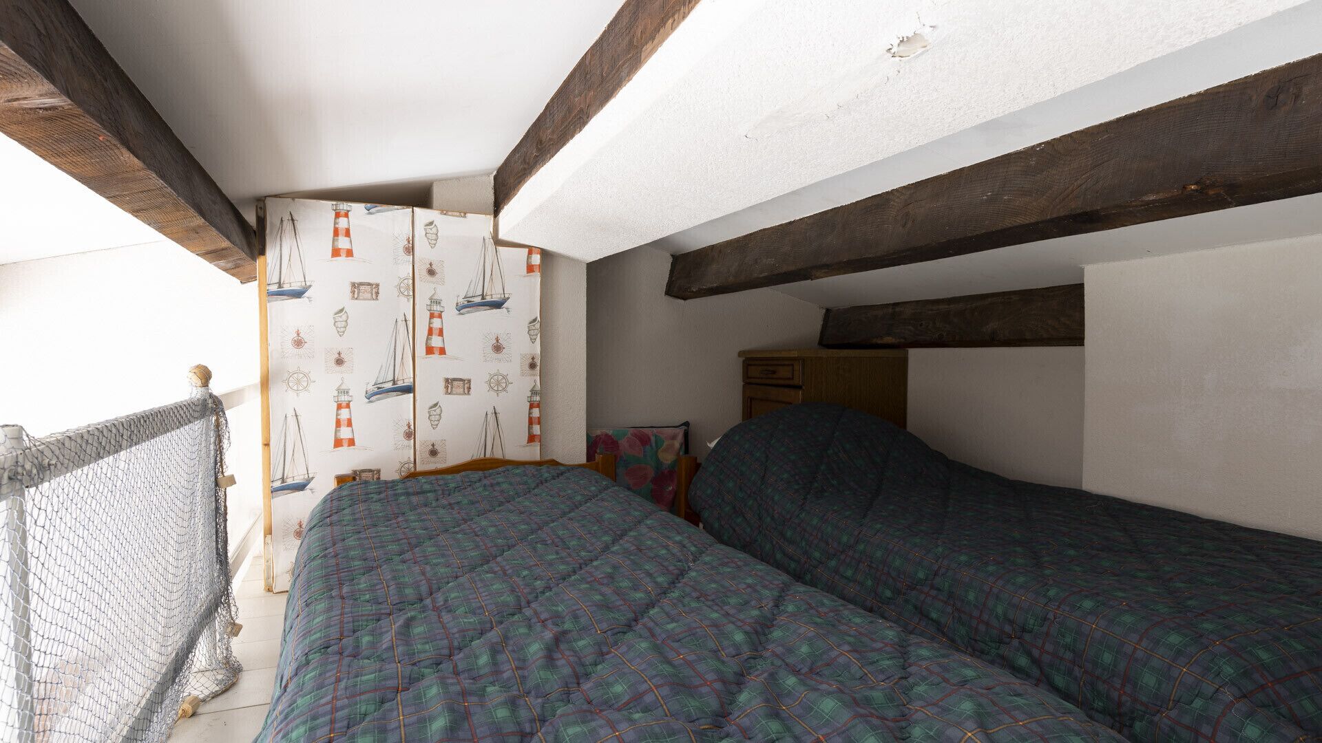 Un dormitorio con cama, una silla y ventana con vistas al exterior.