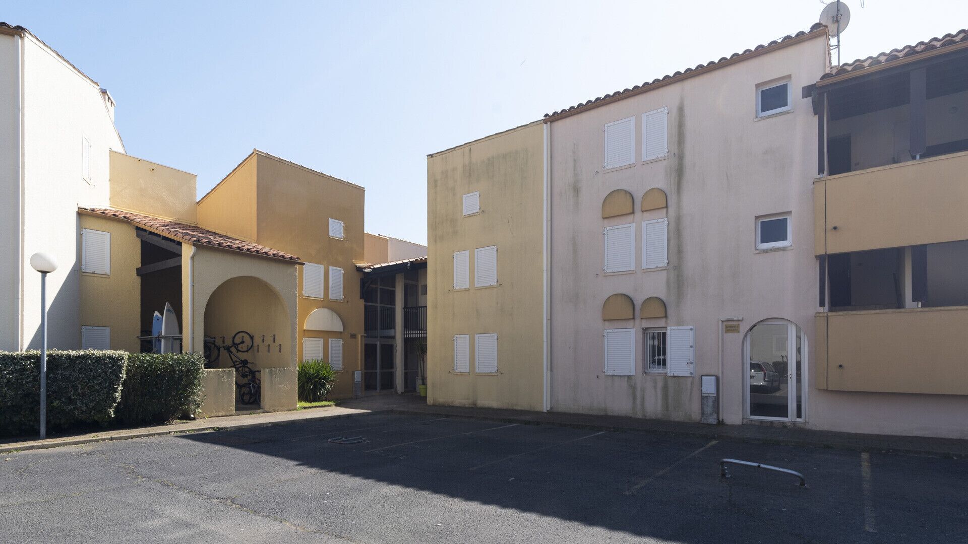 Un bâtiment doté d’une cour intérieure, d’un support à vélos et d’une antenne parabolique.