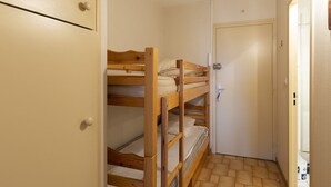 A bunk bed in a small room with a door and a cabinet. - Studio 4 ppl, sea view balcony, pool, parking (Agde)