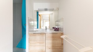 A bathroom with a mirror, sink, and wooden cabinets.