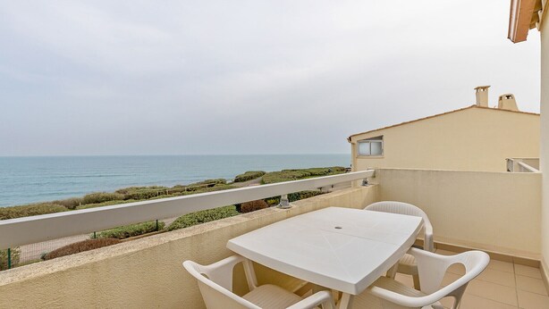 A balcony with a table and chairs, overlooking the sea. - Studio 4 ppl, sea view terrace, private parking (Agde)