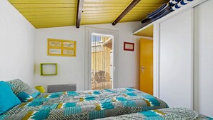 Una camera da letto con un letto, una porta, una finestra e un soffitto giallo.