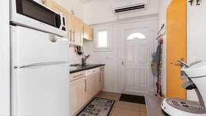 Una cucina compatta con frigorifero, microonde e lavandino.