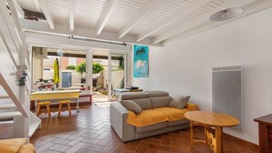 Un amplio espacio habitable con sofá, mesa de comedor y zona de cocina.