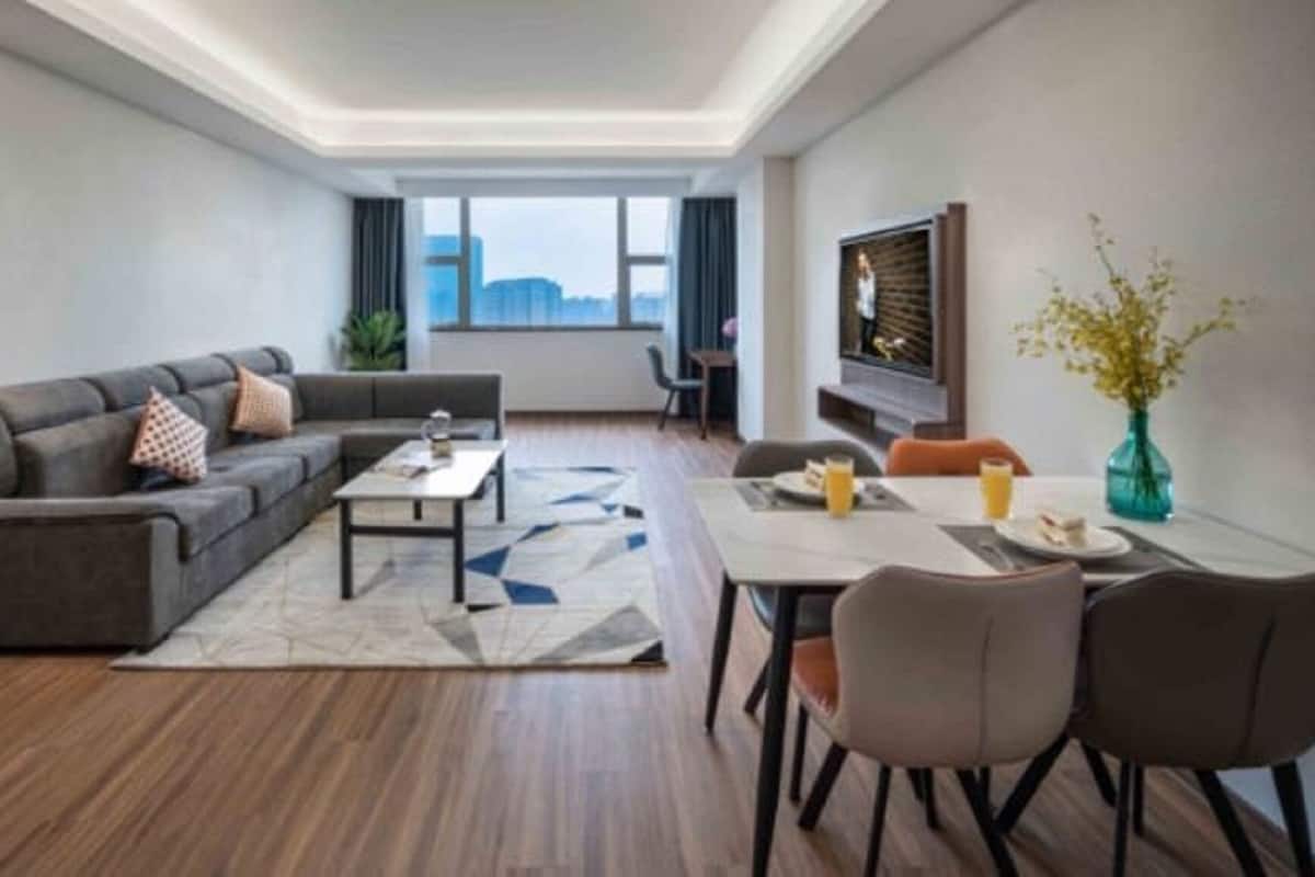 A modern living room with a sectional sofa, a coffee table, and a dining area with chairs.