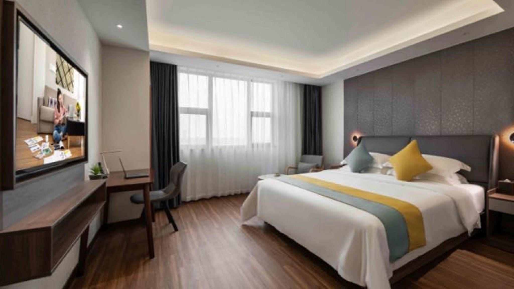 Ein modernes Hotelzimmer mit einem großen Bett, einem Schreibtisch, einem Fernseher und einem Fenster mit Vorhängen.
