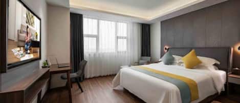 Una habitación de hotel moderna con una cama grande, un escritorio, un televisor y una ventana con cortinas.