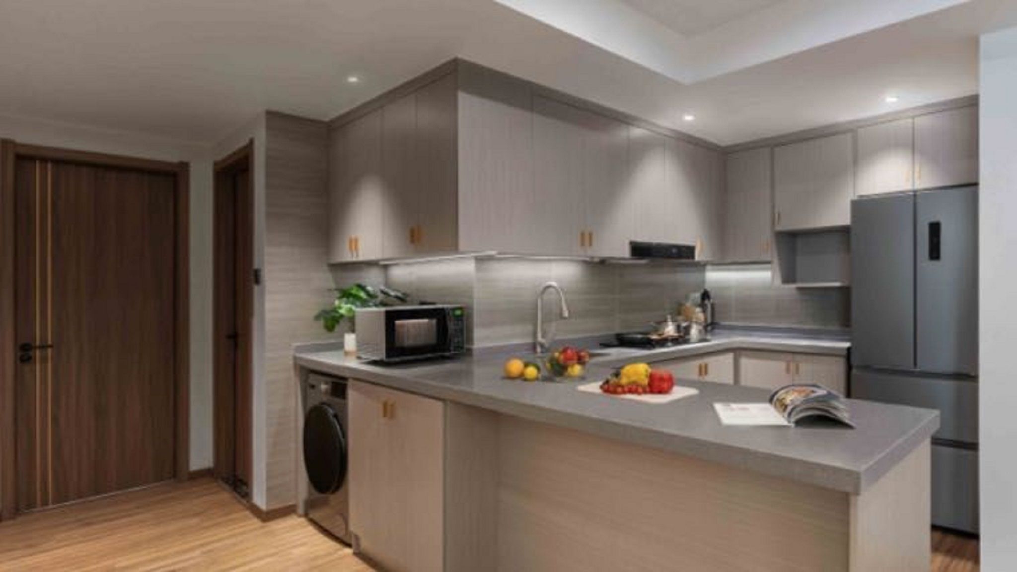A modern kitchen with grey cabinets, a built-in microwave, a sink, and a refrigerator.