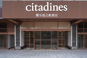Un edificio moderno con un letrero que dice 'Citadines' y caracteres chinos.