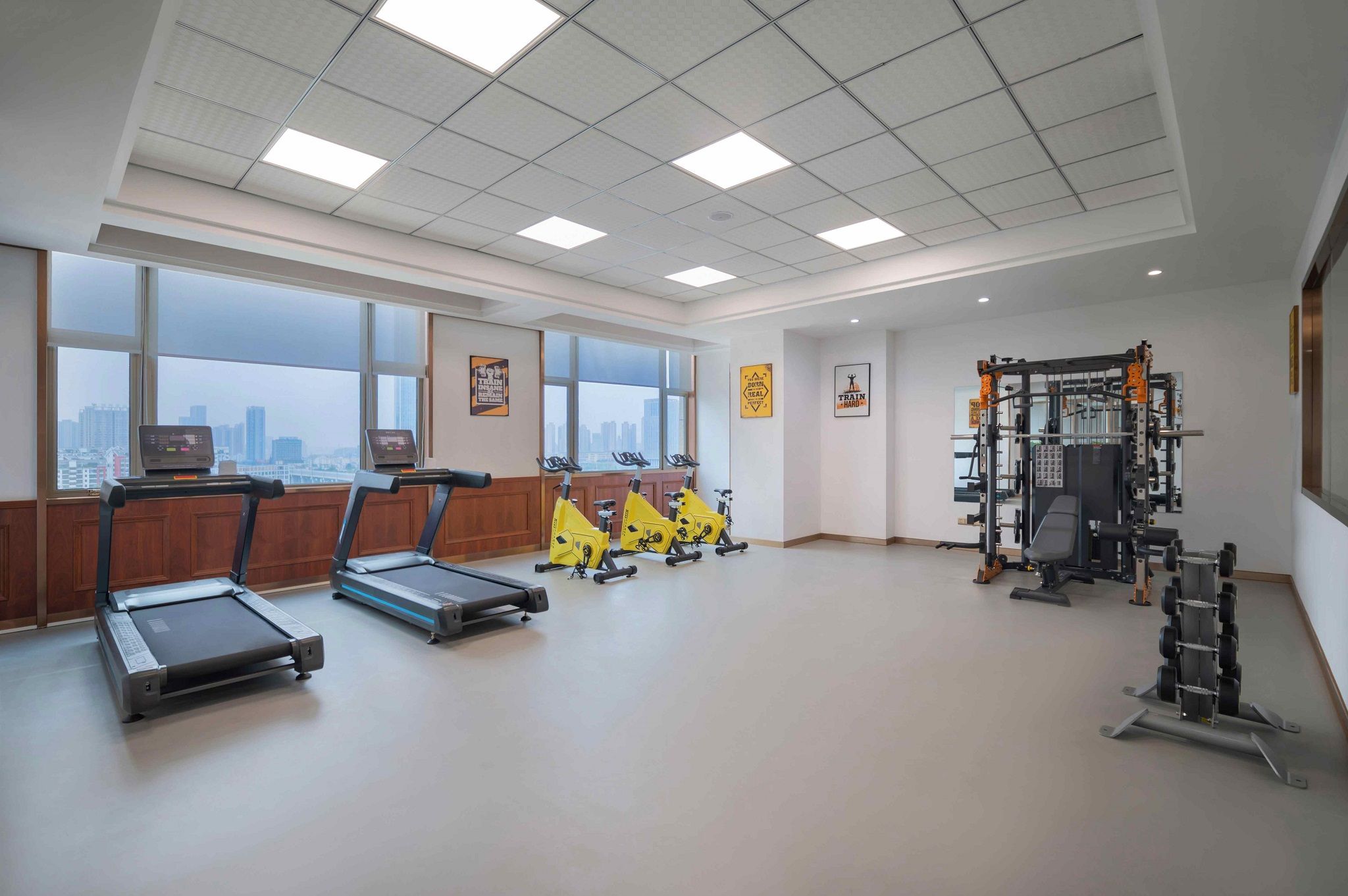 A spacious gym with treadmills, stationary bikes, and weightlifting equipment.