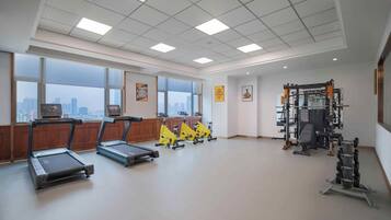 A spacious gym with treadmills, stationary bikes, and weightlifting equipment.