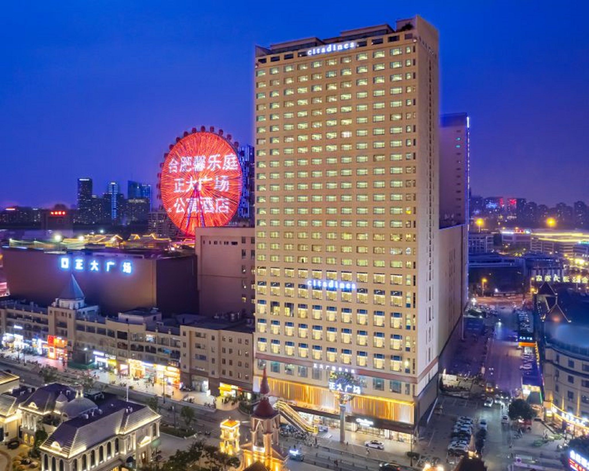 A high-rise hotel with a modern design, featuring a prominent circular structure in the background.