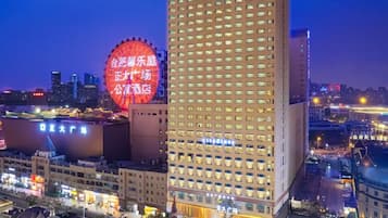 A high-rise hotel with a modern design, featuring a prominent circular structure in the background.