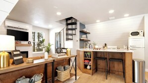 A modern kitchen with a wooden island, built-in shelves, and a compact refrigerator. - *NEW* Hidden Ruby A-Frame (Evergreen)