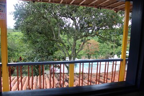 A view from a balcony with a tiled floor, a railing, and a tree in the background. - Finca la colmena de don juaco  (Montenegro)
