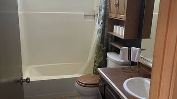 Une petite salle de bain comprenant une baignoire, des toilettes et un lavabo.