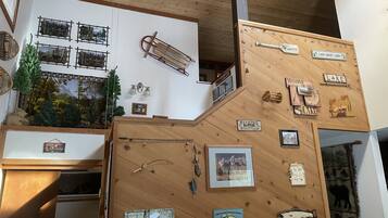 L’intérieur d’une cabane avec des murs en bois, une fronde, des panneaux indiquant la présence d’un lieu de pêche et une pancarte de bienvenue.