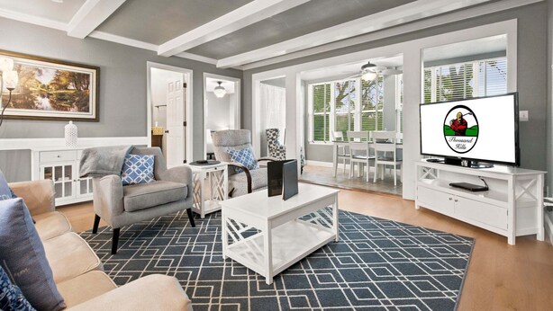 A living room with a sofa, coffee table, TV, and a painting on the wall. - Walk-in Golf Course View Condo with Lock-off Double Suite (Branson)