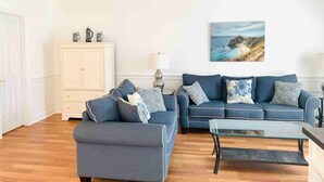 Un salon comprenant un canapé, une table basse et un meuble.