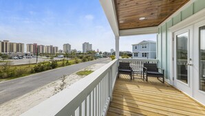 Eine Holzterrasse mit Geländer, einer Bank und einem Tisch.