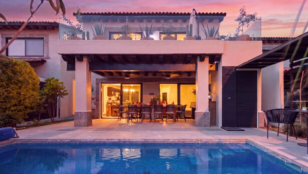 Une maison moderne dotée d’une piscine, d’un patio et d’un espace repas.