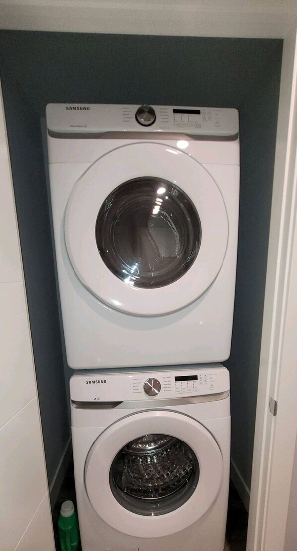 Una lavadora y secadora apiladas en un cuarto de lavandería.