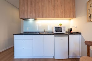 A compact kitchen with a microwave, sink, and dishwasher.