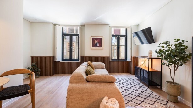 A modern living room with a sofa, a TV, a plant, and a fireplace. - Cozy Apartment only 500m from Douro River | With A/C by Lisbeyond (Vila Nova de Gaia)