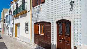Una stretta strada acciottolata fiancheggiata da edifici colorati, ciascuno con stili architettonici e piastrelle decorative differenti.