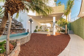 Stroll through the serene garden, surrounded by a soothing water feature and a small pool.