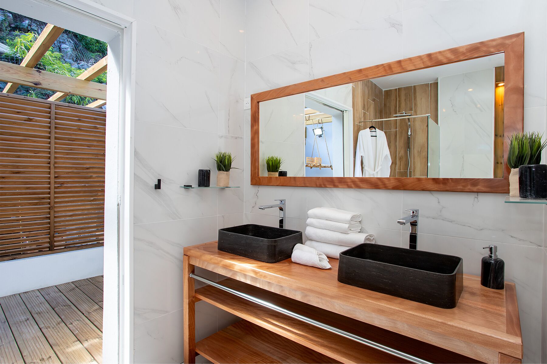 Une salle de bain moderne avec un meuble-lavabo en bois, deux vasques noires, un grand miroir et un plafond en bois.