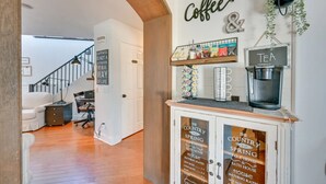 Una sala de estar acogedora con una escalera, un rincón para café y un cartel que indica Hotel Country Spring.