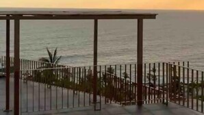 Una terraza con vista al mar durante el atardecer.