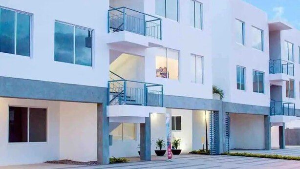 A modern multi-story building with balconies, large windows, and a flat roof. - CONDOS AA (Mazatlán)
