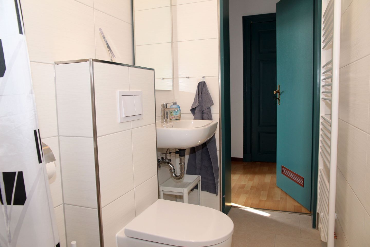 A bathroom with a toilet, sink, and shower area.