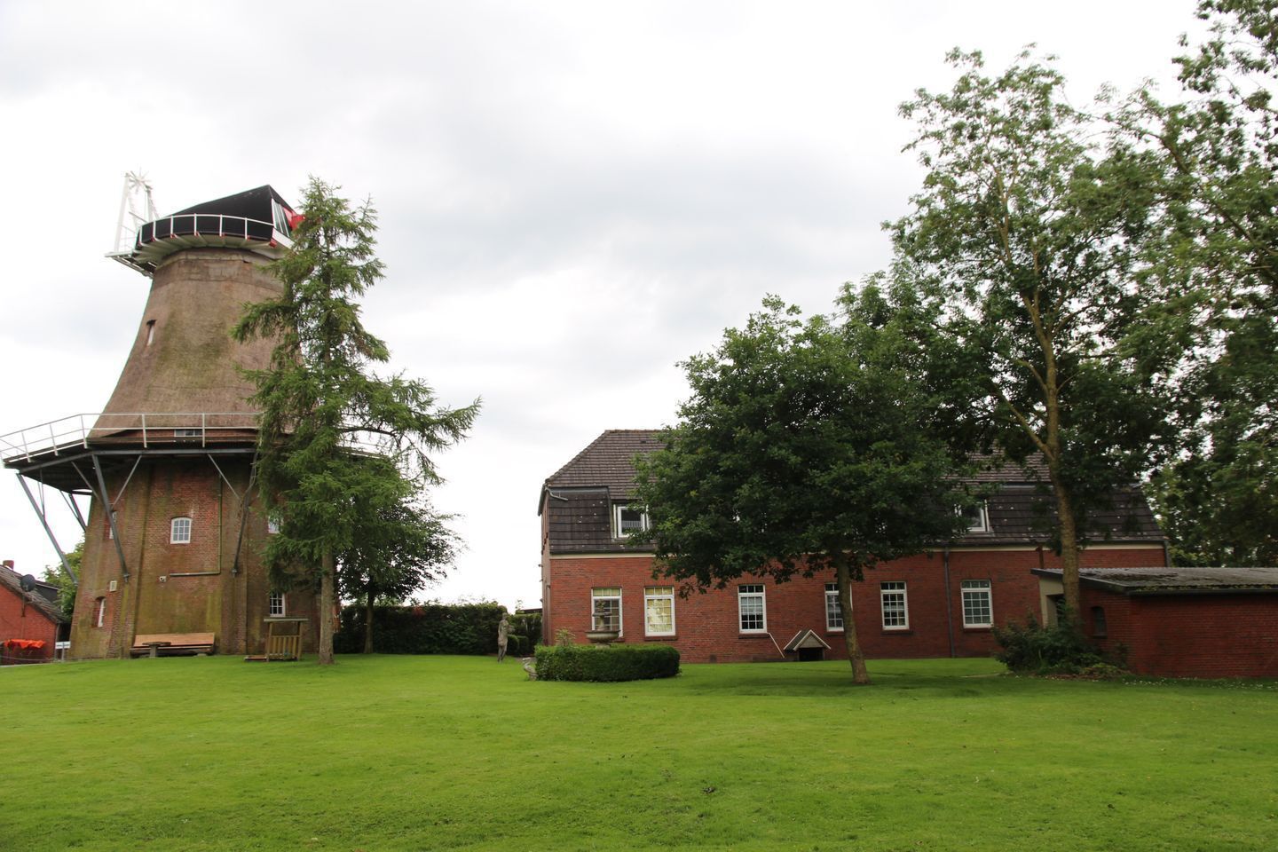 A traditional windmill with a brick building adjacent to it.